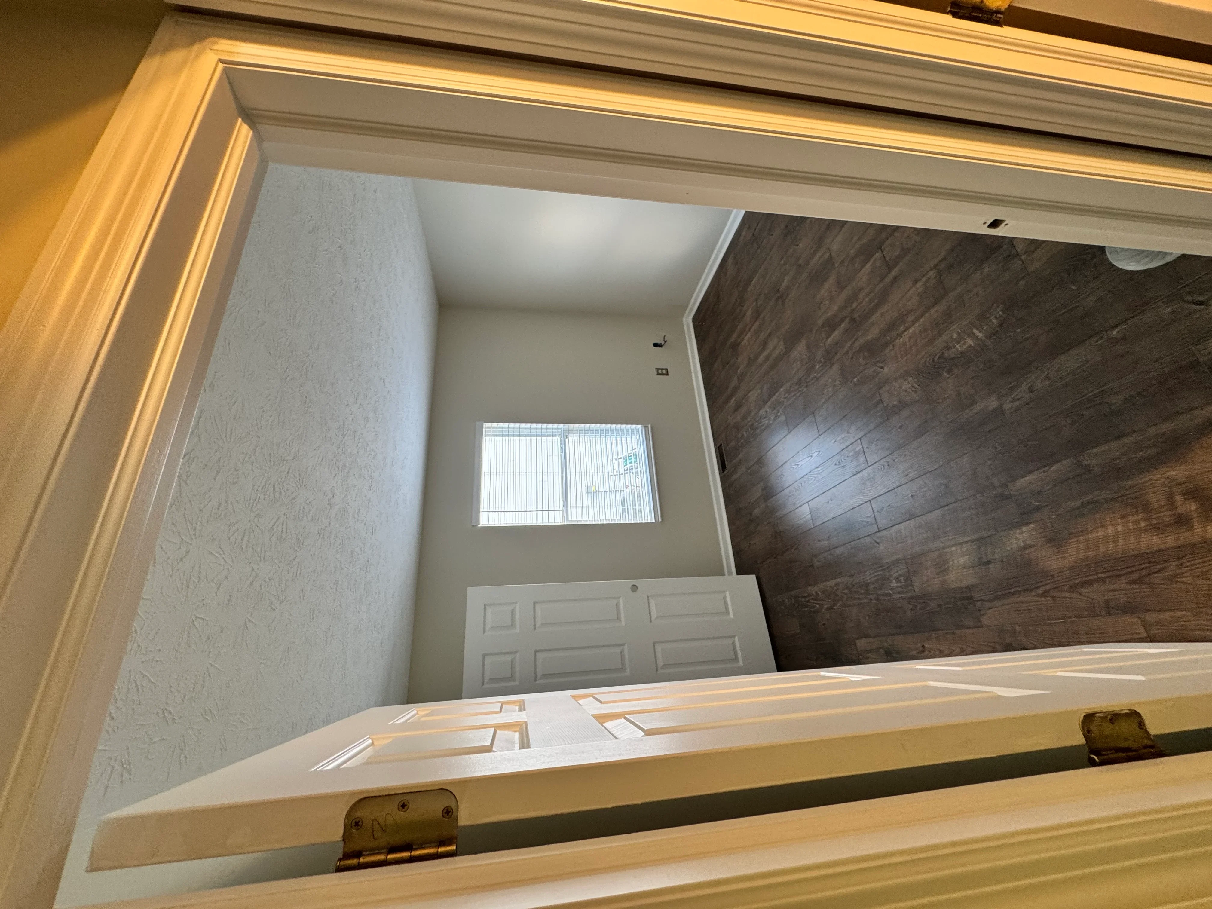 Newly renovated garage interior with textured walls, dark flooring, and white garage door