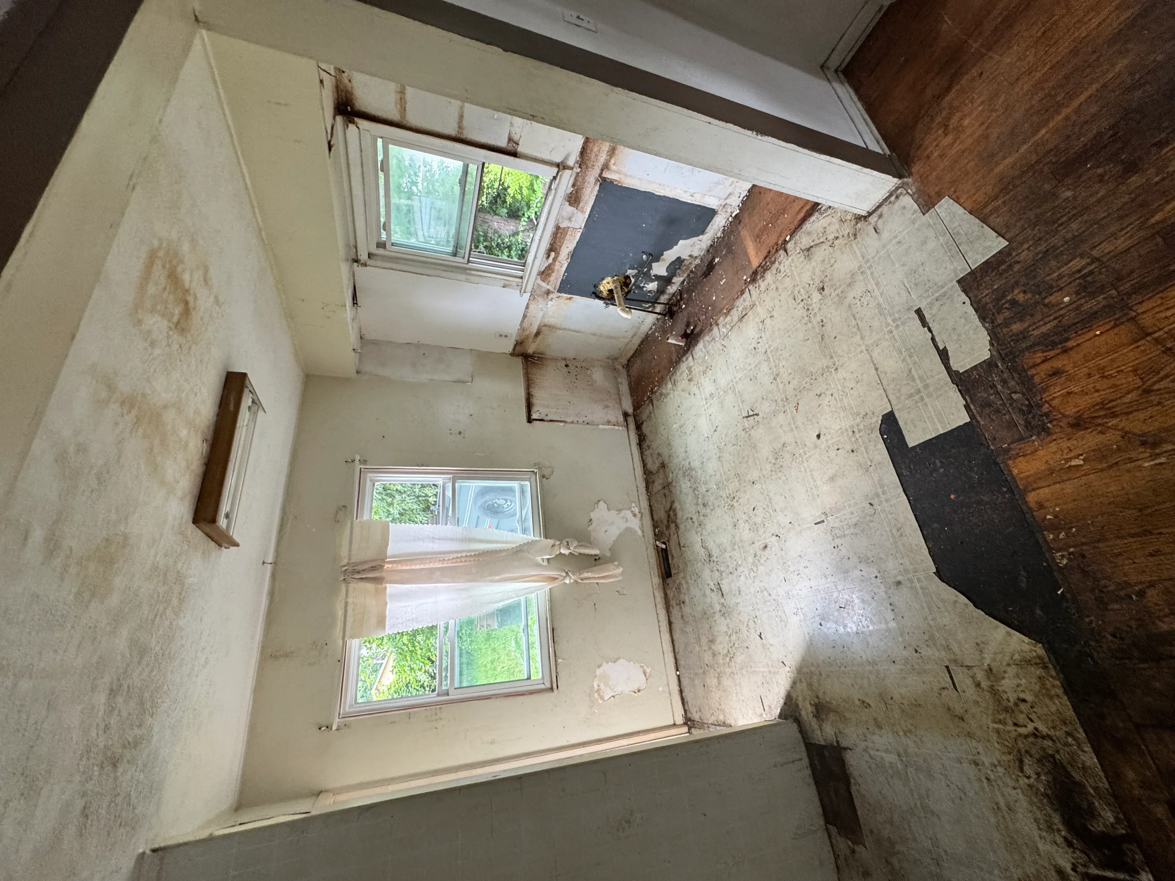 Interior room stripped to structural elements with exposed brick, concrete, and wooden framing