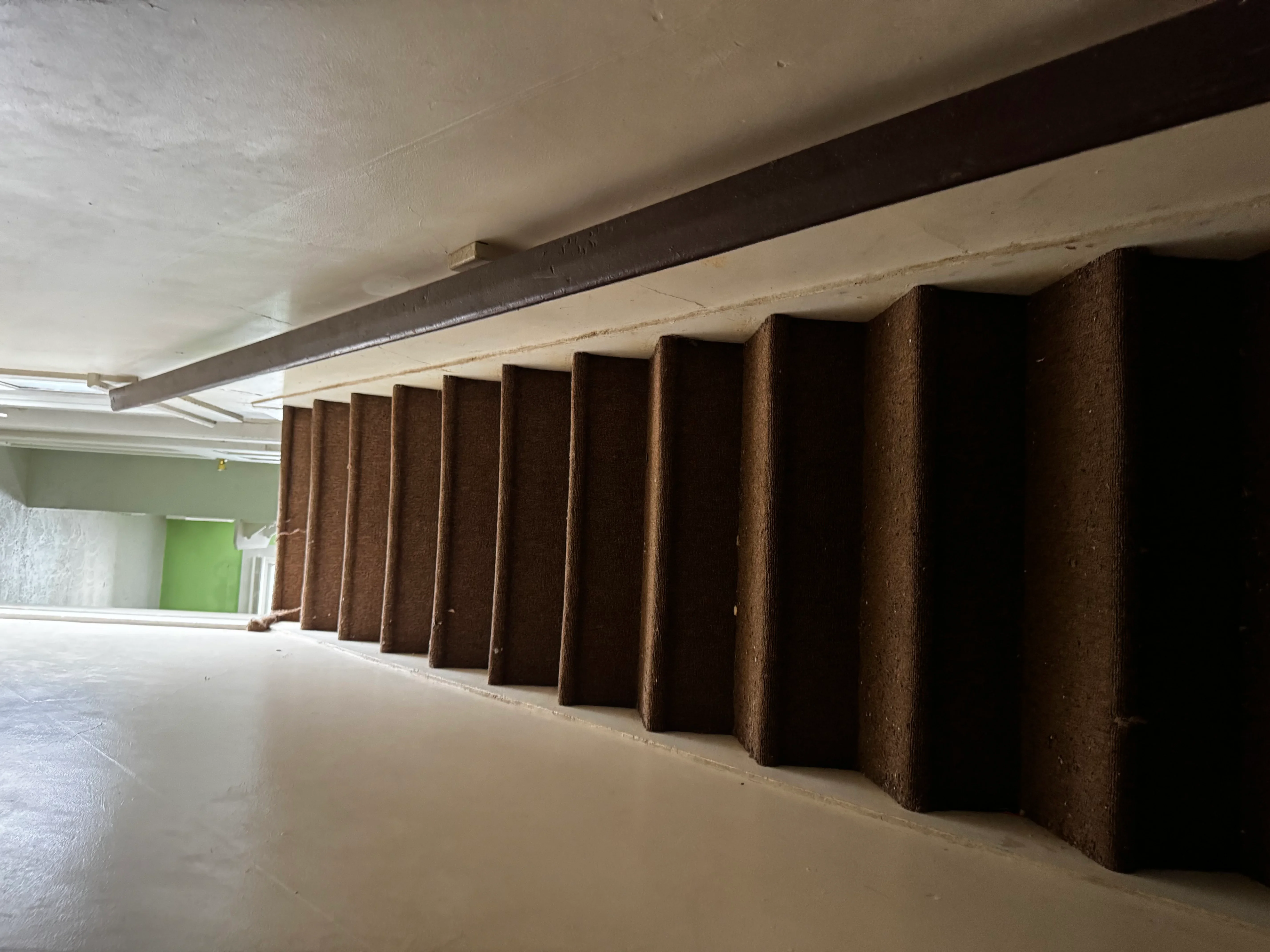 Interior demolition showing exposed steel beam and concrete floor with removed wall sections