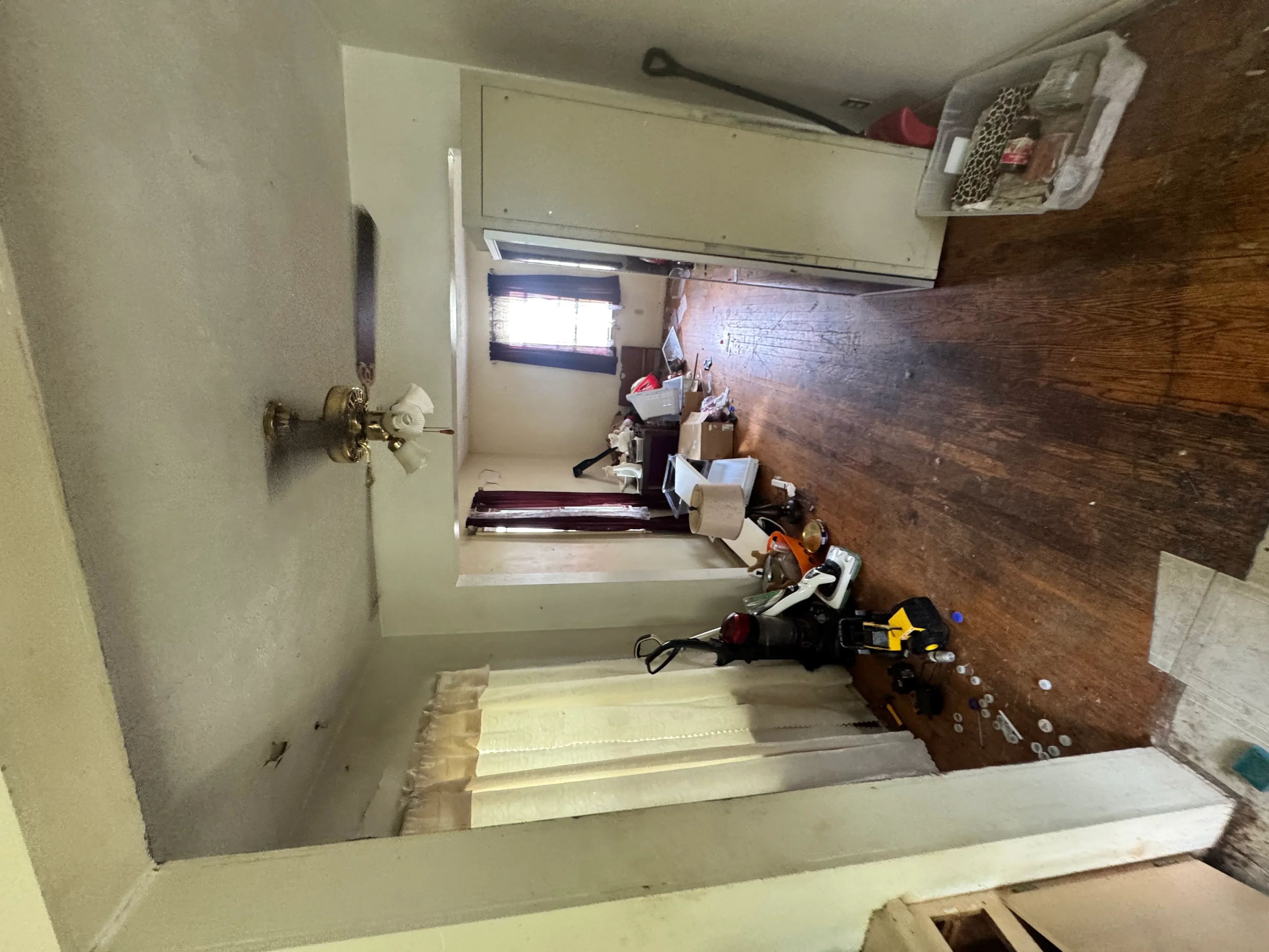 Bedroom under renovation with new hardwood flooring and fresh drywall installation