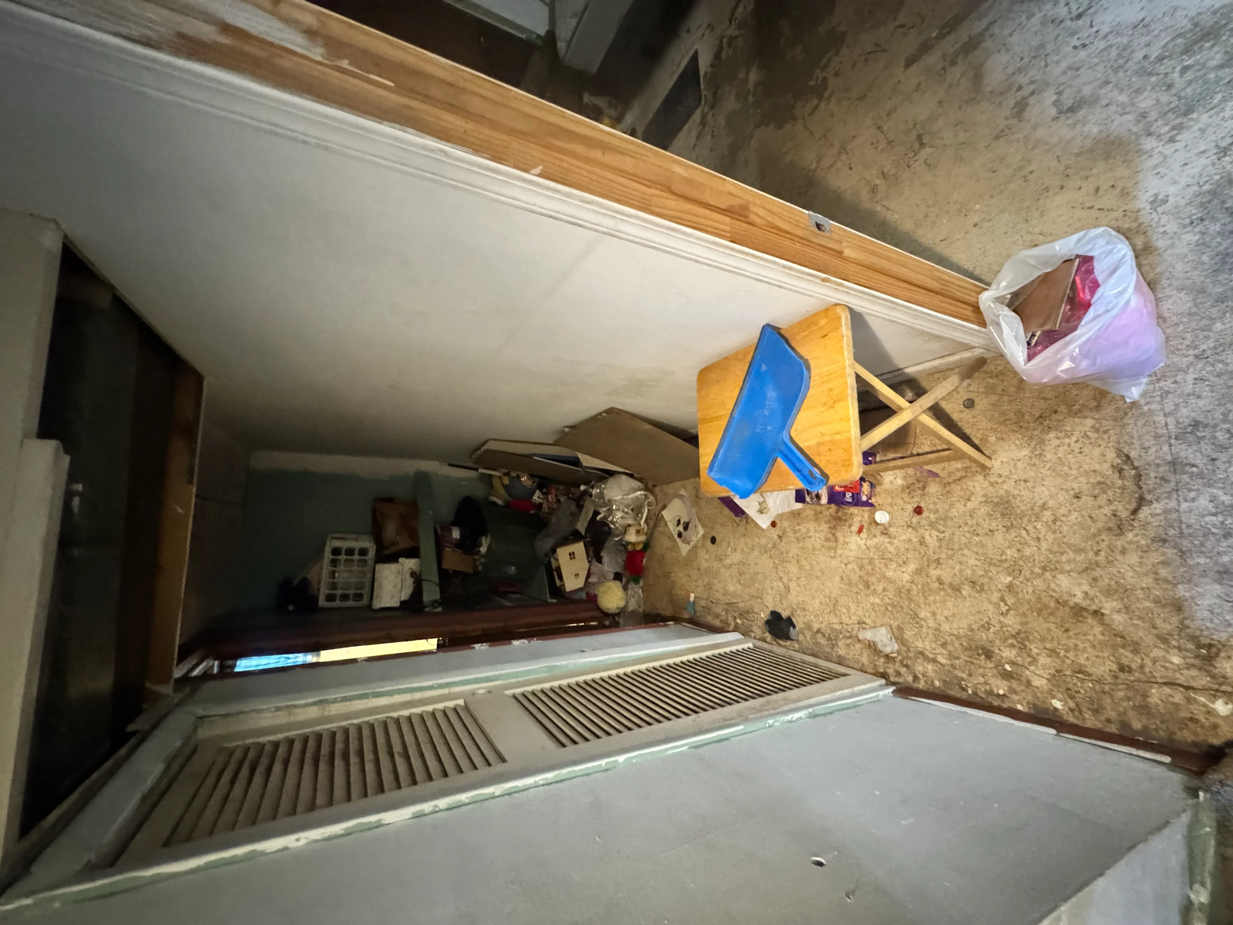 Basement demolition in progress with exposed concrete walls and cleared flooring