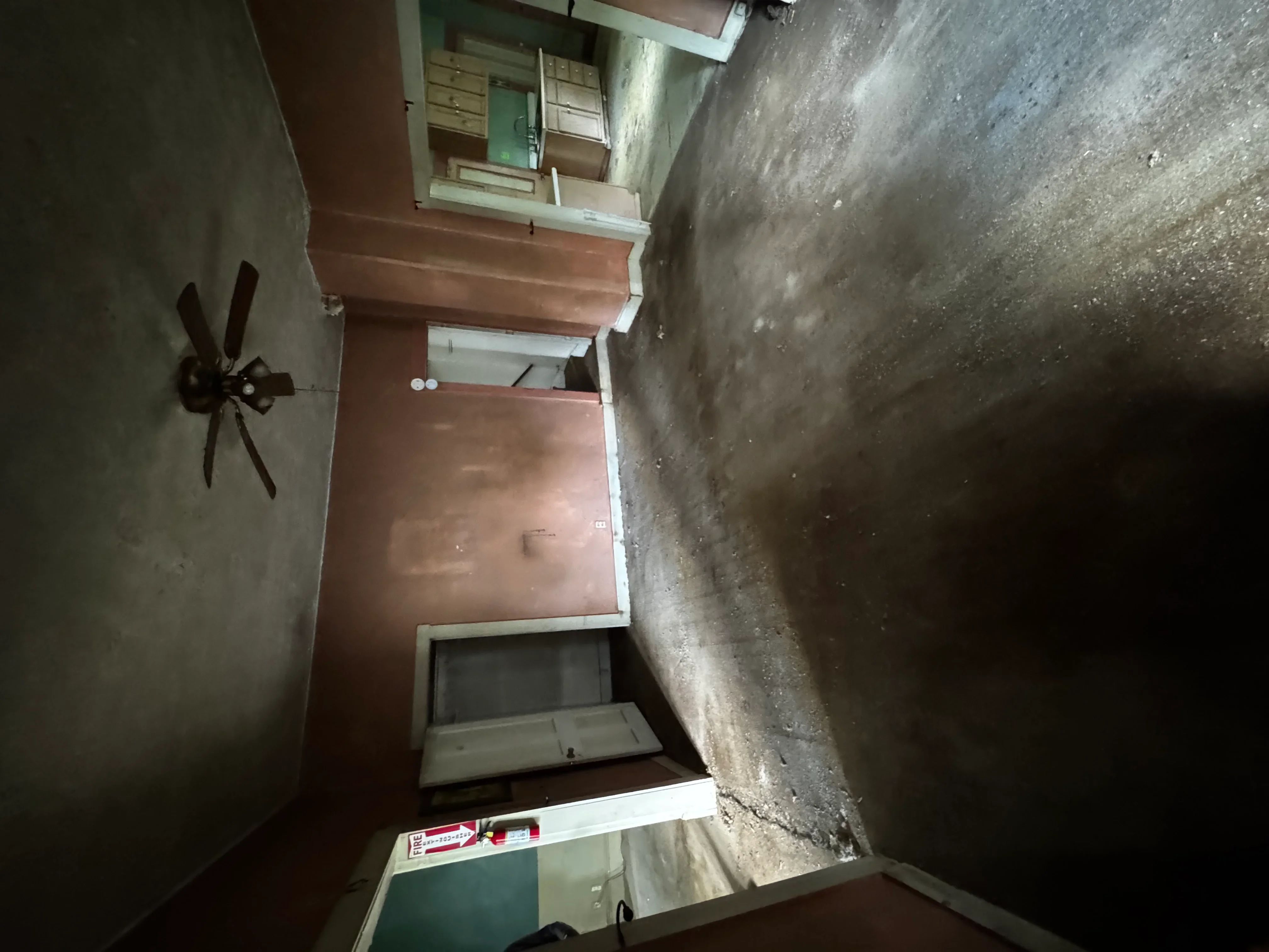 Interior demolition project showing exposed concrete walls and removed drywall in residential space