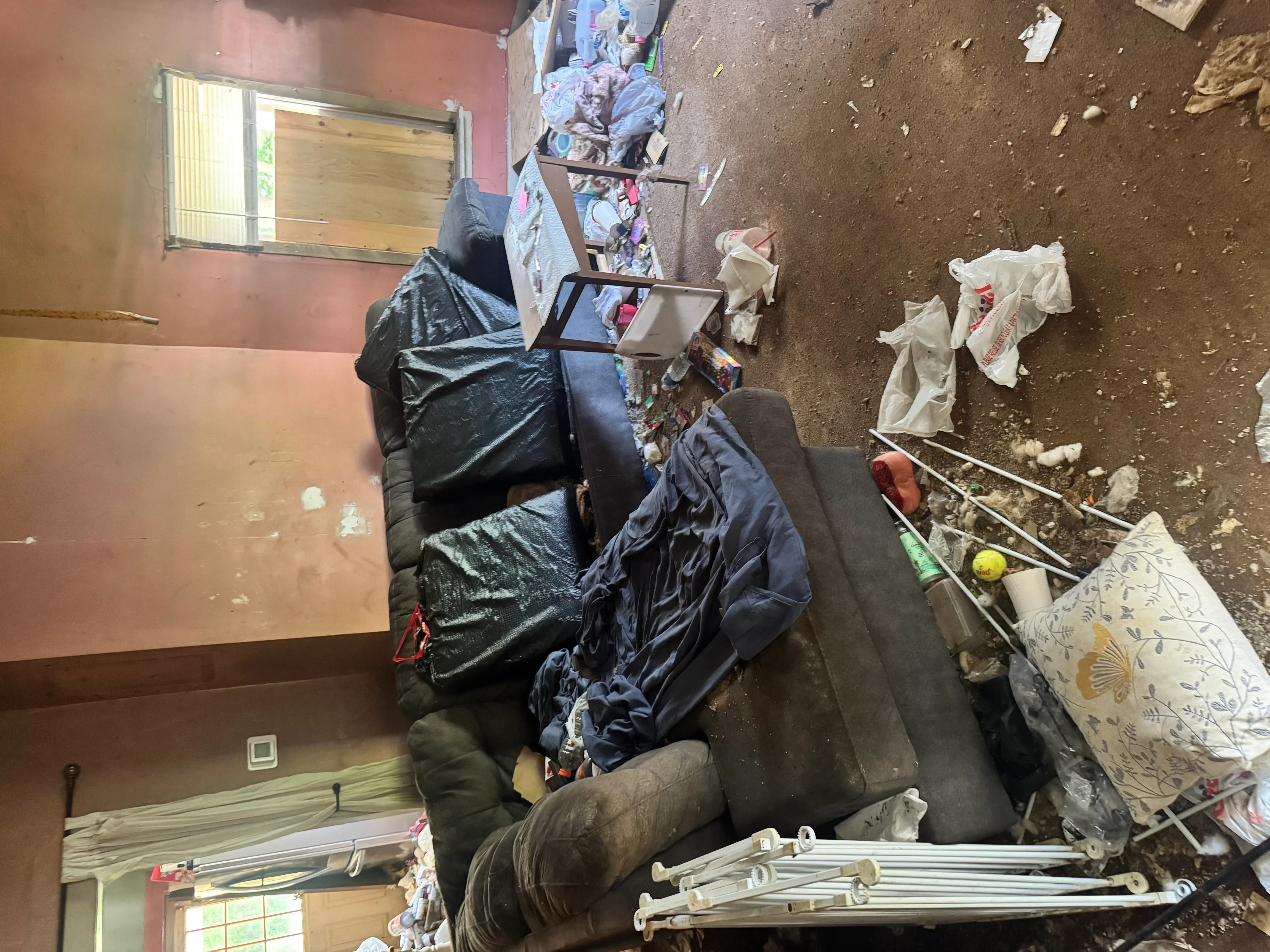 Interior space cleared of junk including black bags, furniture, and household debris