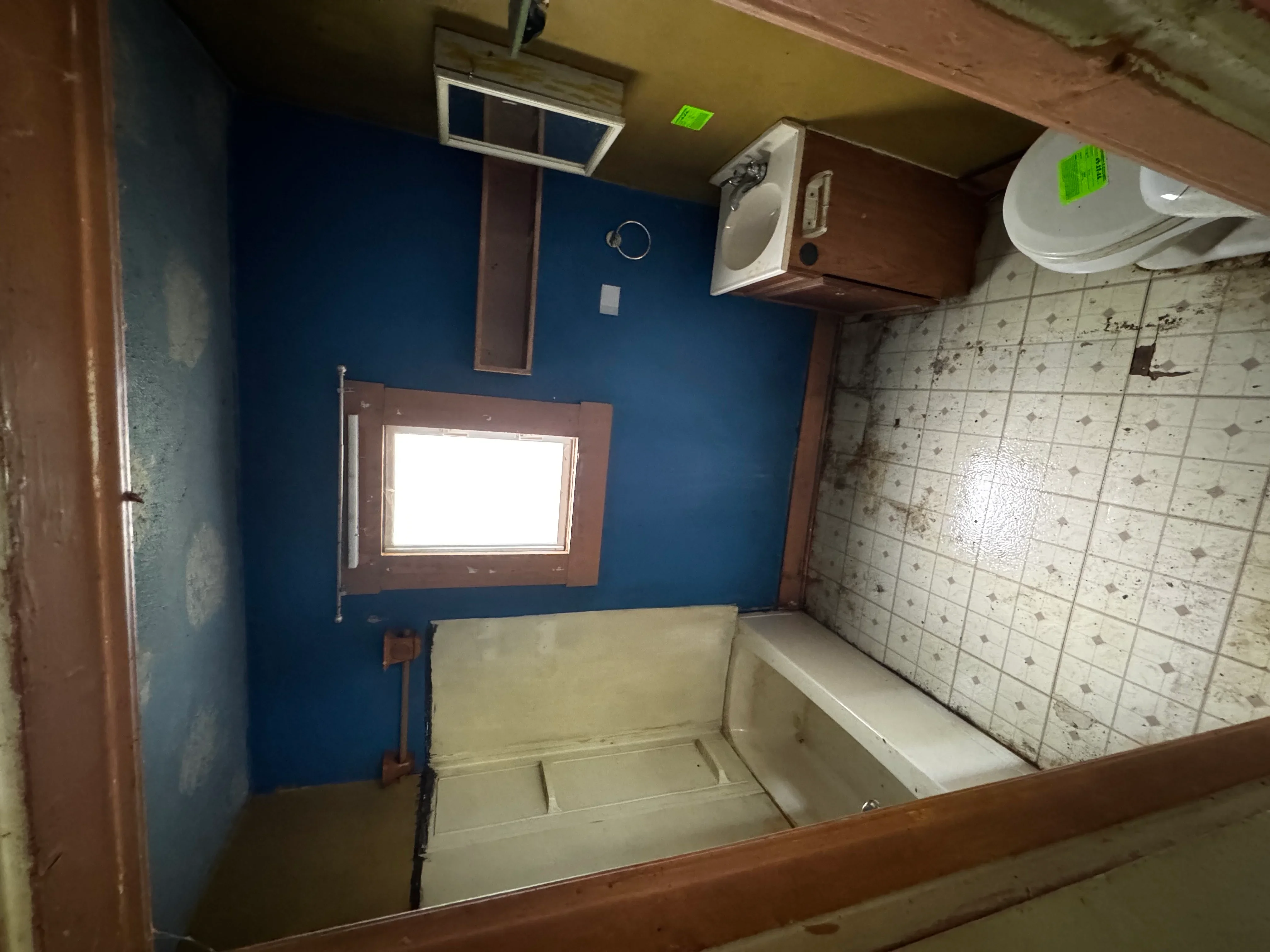 Renovated bathroom with blue walls, patterned tile shower surround, and updated fixtures